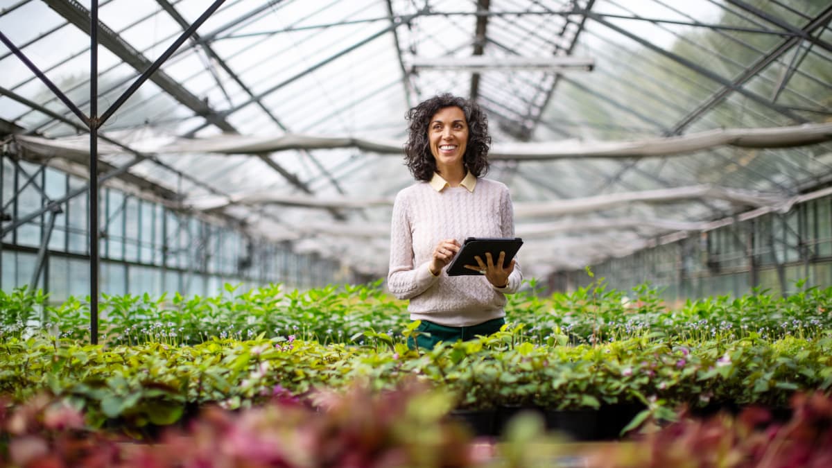 Frau mit Tablet bei der Gartenarbeit