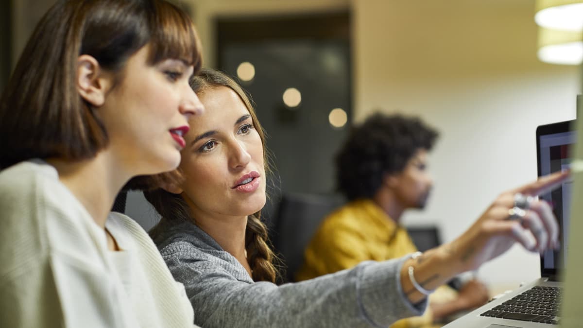 co-workers looking together forward on desktop