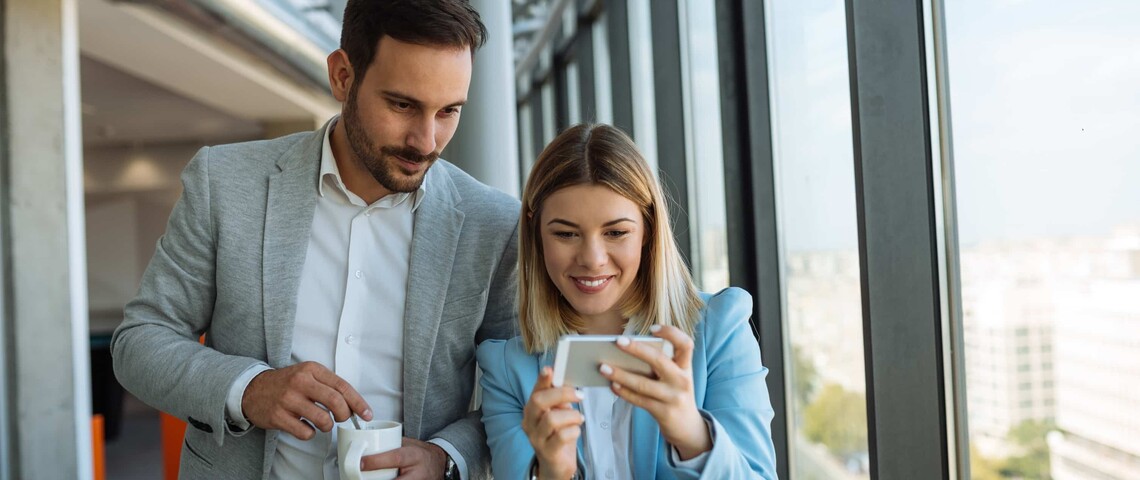 deux collègues regardent leur smartphone