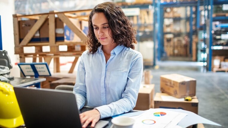 woman working on computer in a a warehouse